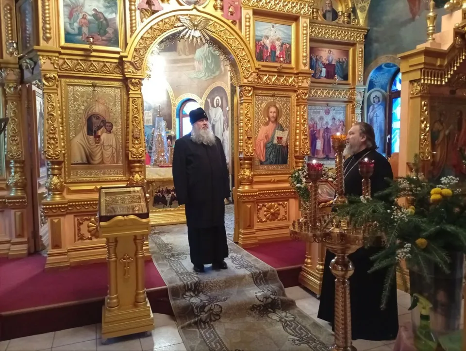 Митрополит и настоятель в интерьере храма перед иконостасом